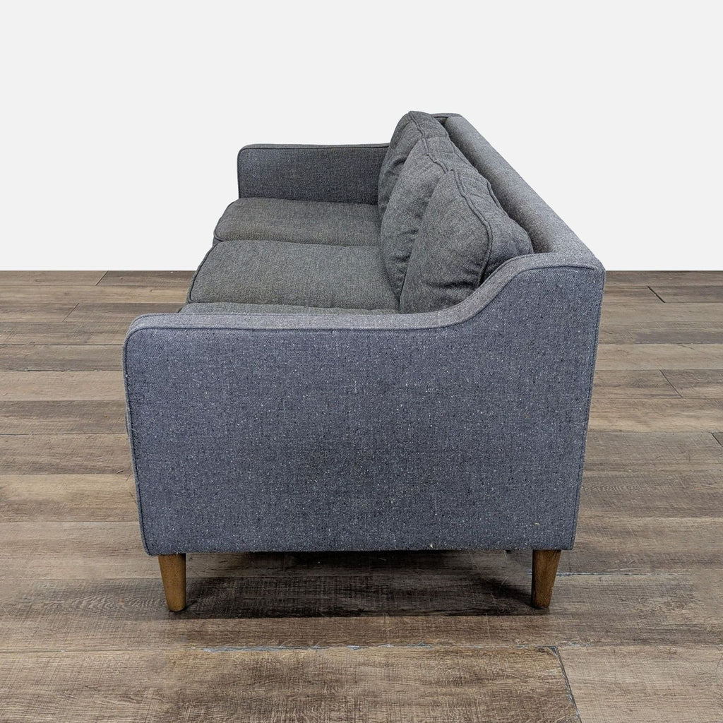 3. Profile view of a West Elm 3-seat tweed sofa, featuring cushioned seats and wooden legs.