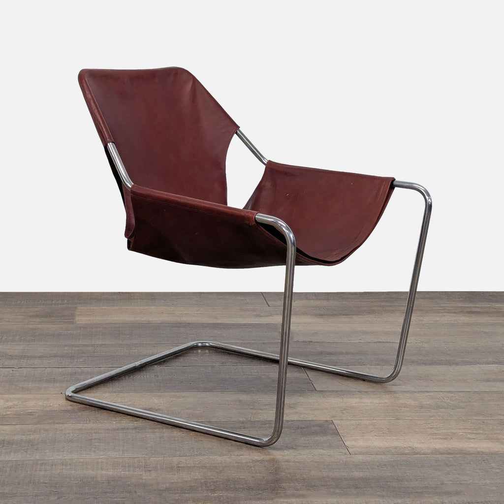 3. Three-quarter angle of the Reperch Paulistano Armchair, highlighting its continuous steel frame and rich leather.