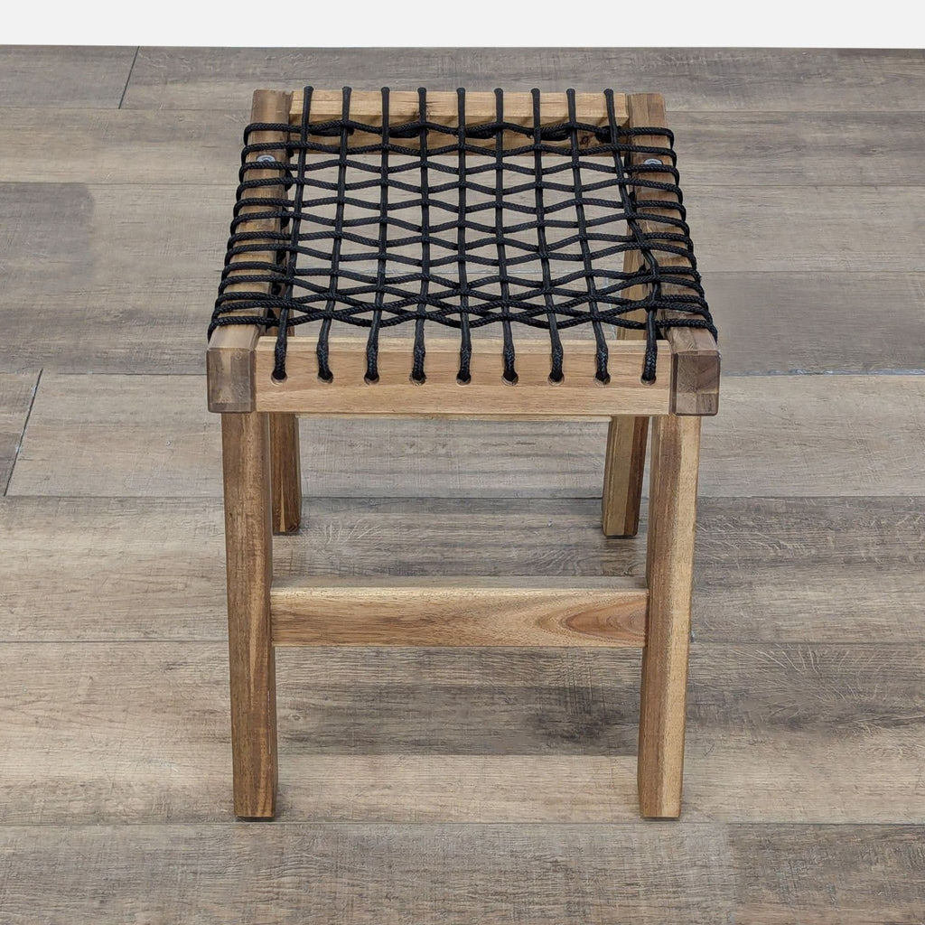 Rectangular wooden stool by Reperch with a black rope grid seat, viewed from above for detail.  