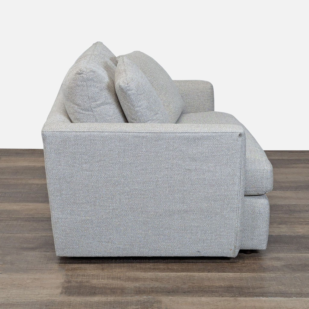 2. Side profile of Crate & Barrel loveseat showing thick cushions and structured track arm design.