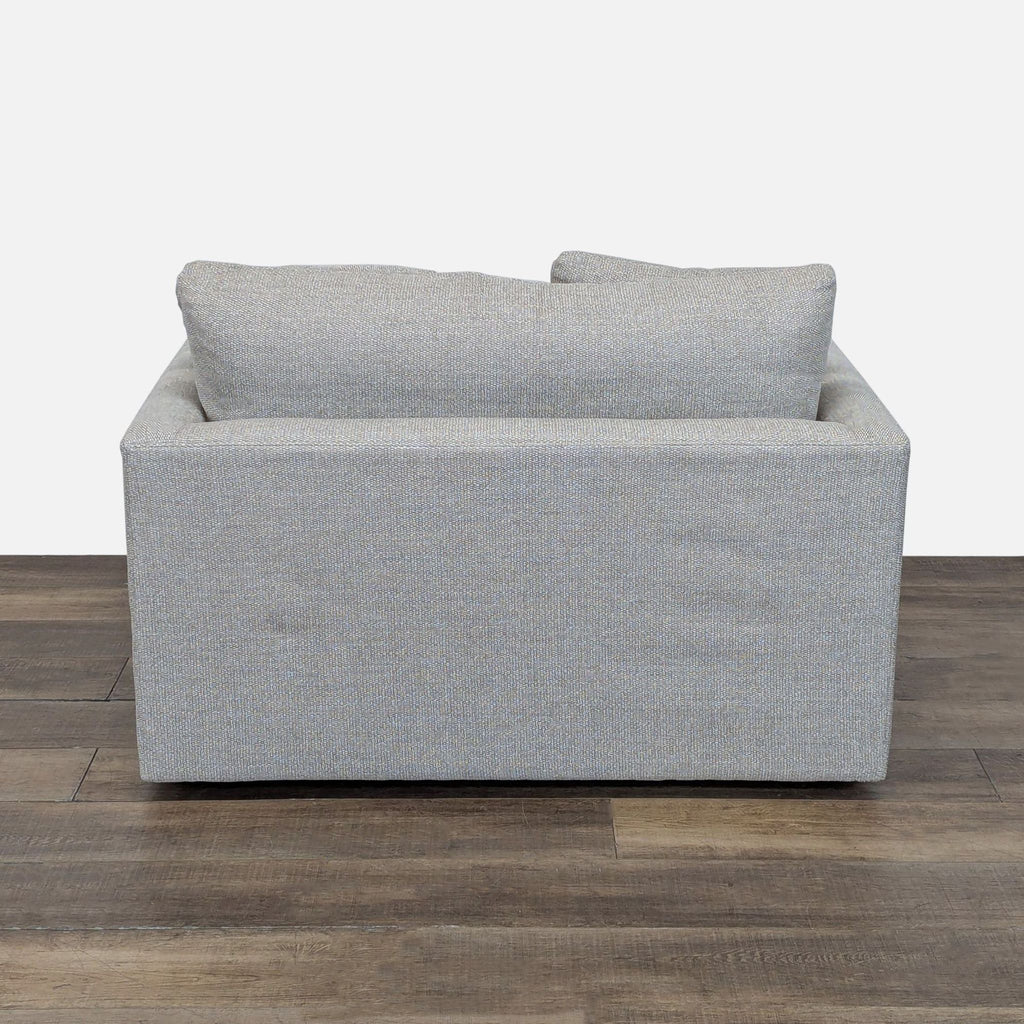 3. Rear view of Crate & Barrel loveseat, highlighting its boxy shape and cushioned back.