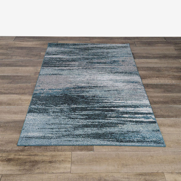 1. Dalyn rug with modern teal and grey abstract design, machine-made from polypropylene, displayed on wood floor.