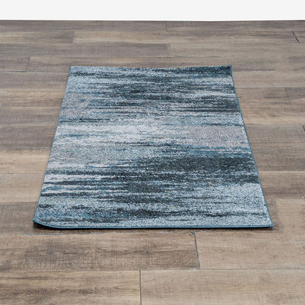 1. Dalyn machine-made polypropylene rug with a blue and gray abstract pattern, shown on a wood floor.  