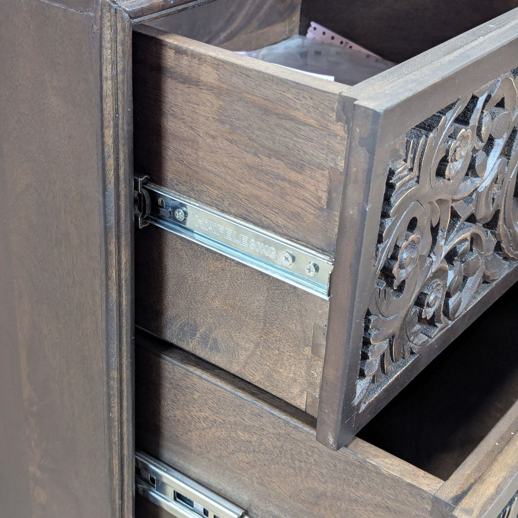 Close-up of Reperch end table drawer, highlighting floral carvings and metal sliding mechanism.