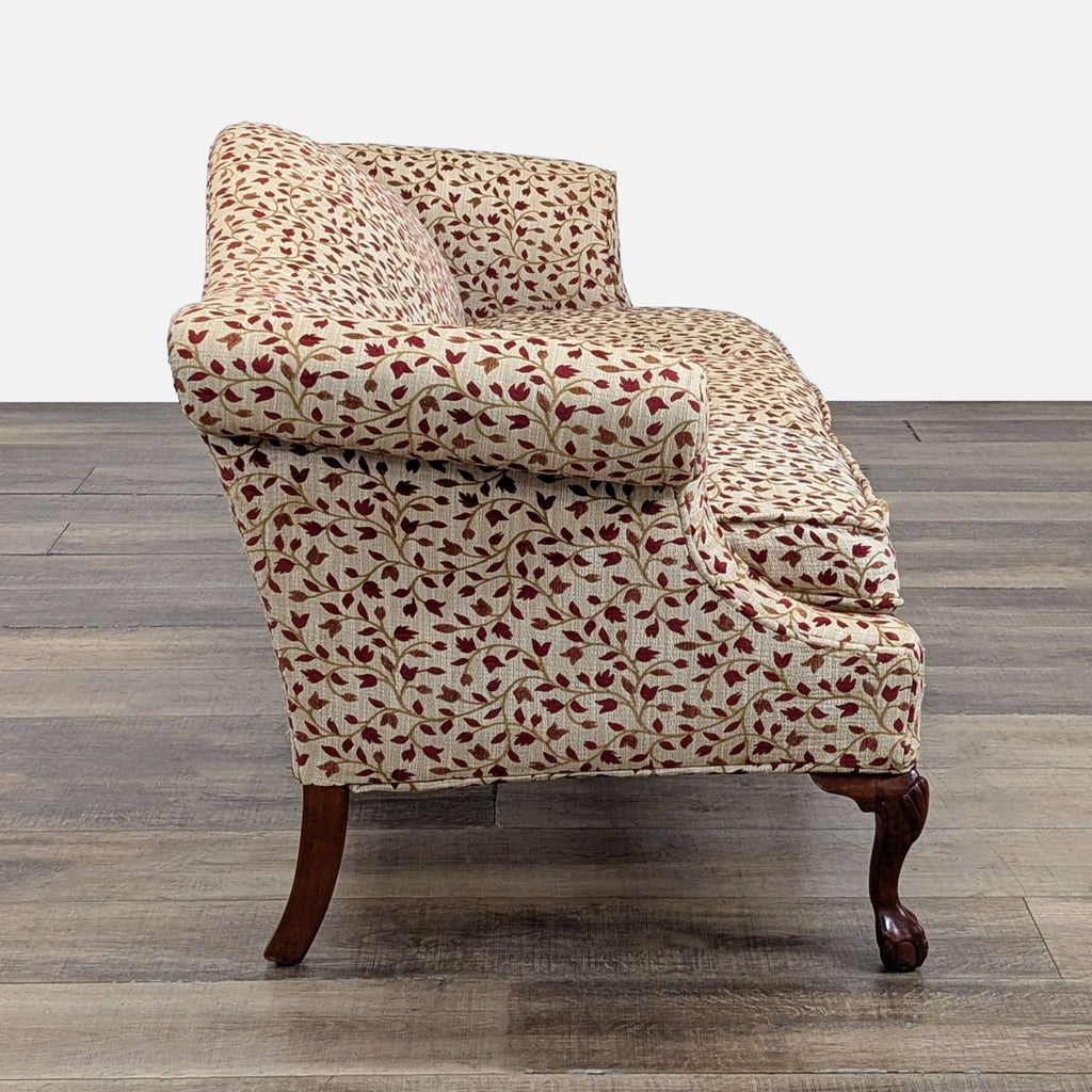 Side profile of a Reperch floral-patterned 3-seat sofa featuring rolled arms and carved wood feet.  