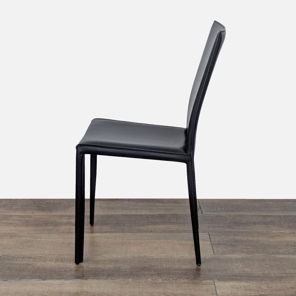 3. Side profile of a modern EQ3 black leather dining chair with simple, clean lines.