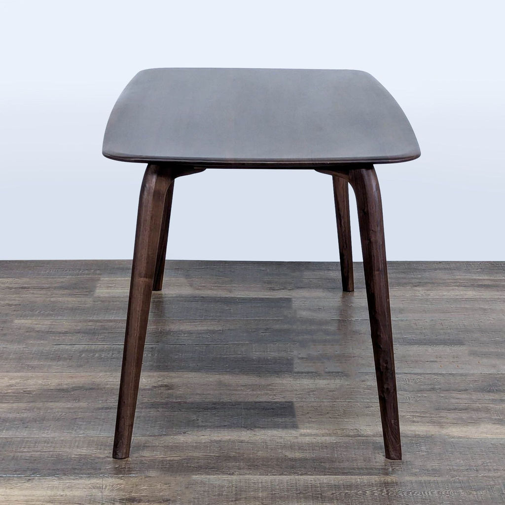3. End-on perspective of a Castlery dining table highlighting its rectangular top and elegantly tapered legs.