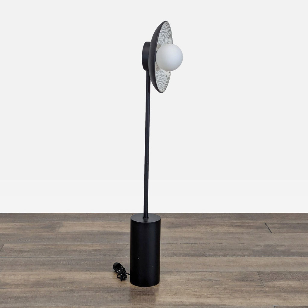 Side view of Anthropologie lamp showing black cylindrical base and bulb with decorative ceramic shade, Lighting.