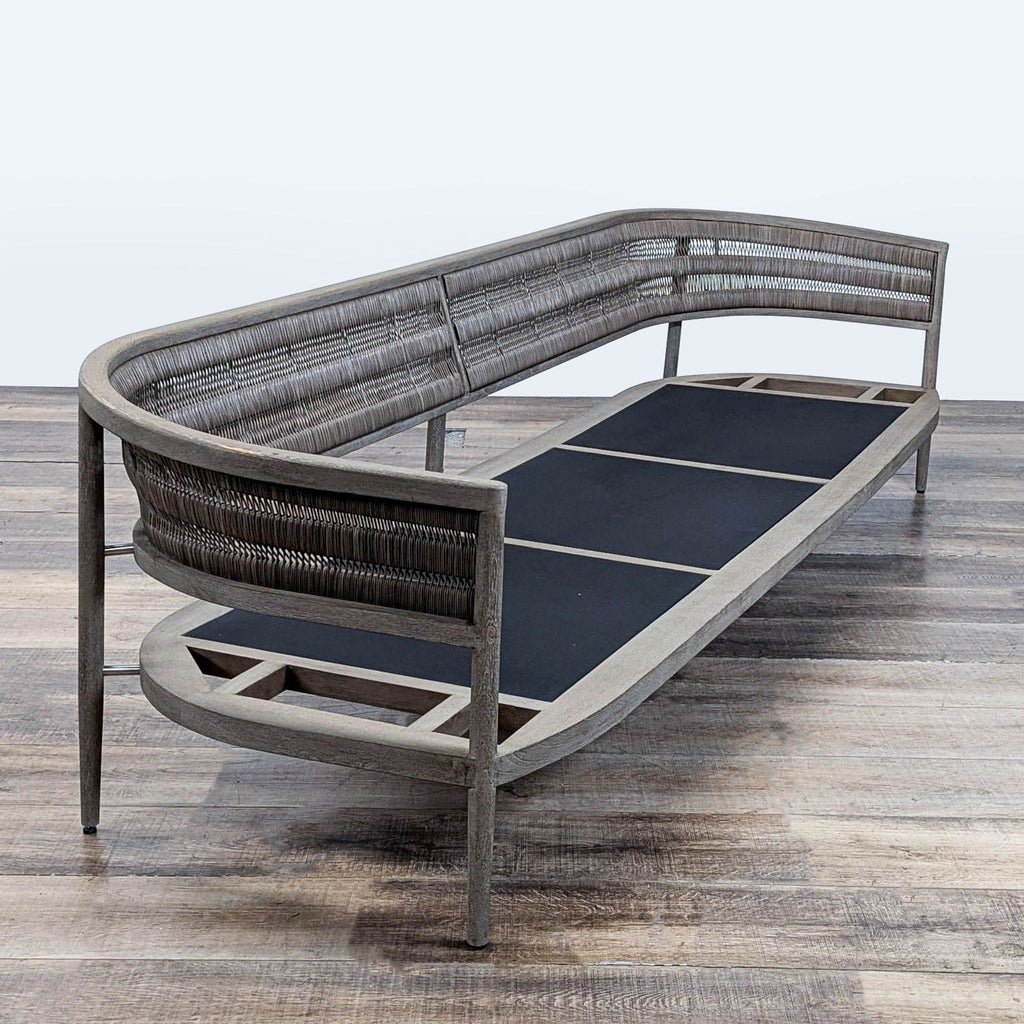 3. Angled shot of Restoration Hardware chair featuring a teak frame, tapered legs, and a curved wicker back, no cushions.