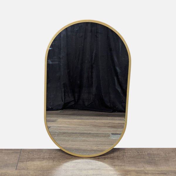 1. Reperch brand arched mirror with a thin gold frame, placed on a wooden floor and reflecting a dark curtain.