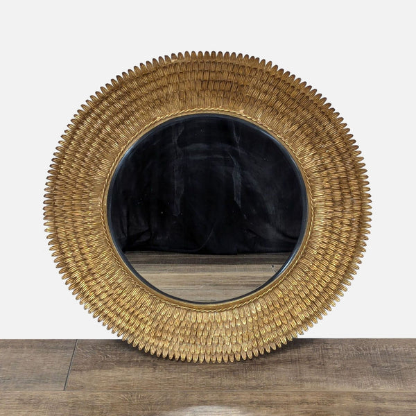 1. Round Reperch mirror with a gold textured frame resembling overlapping feathers, displayed on a wooden surface.