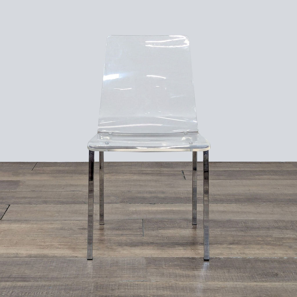 1. CB2 clear acrylic chair with slim nickel legs, shown from the front on a wooden floor.