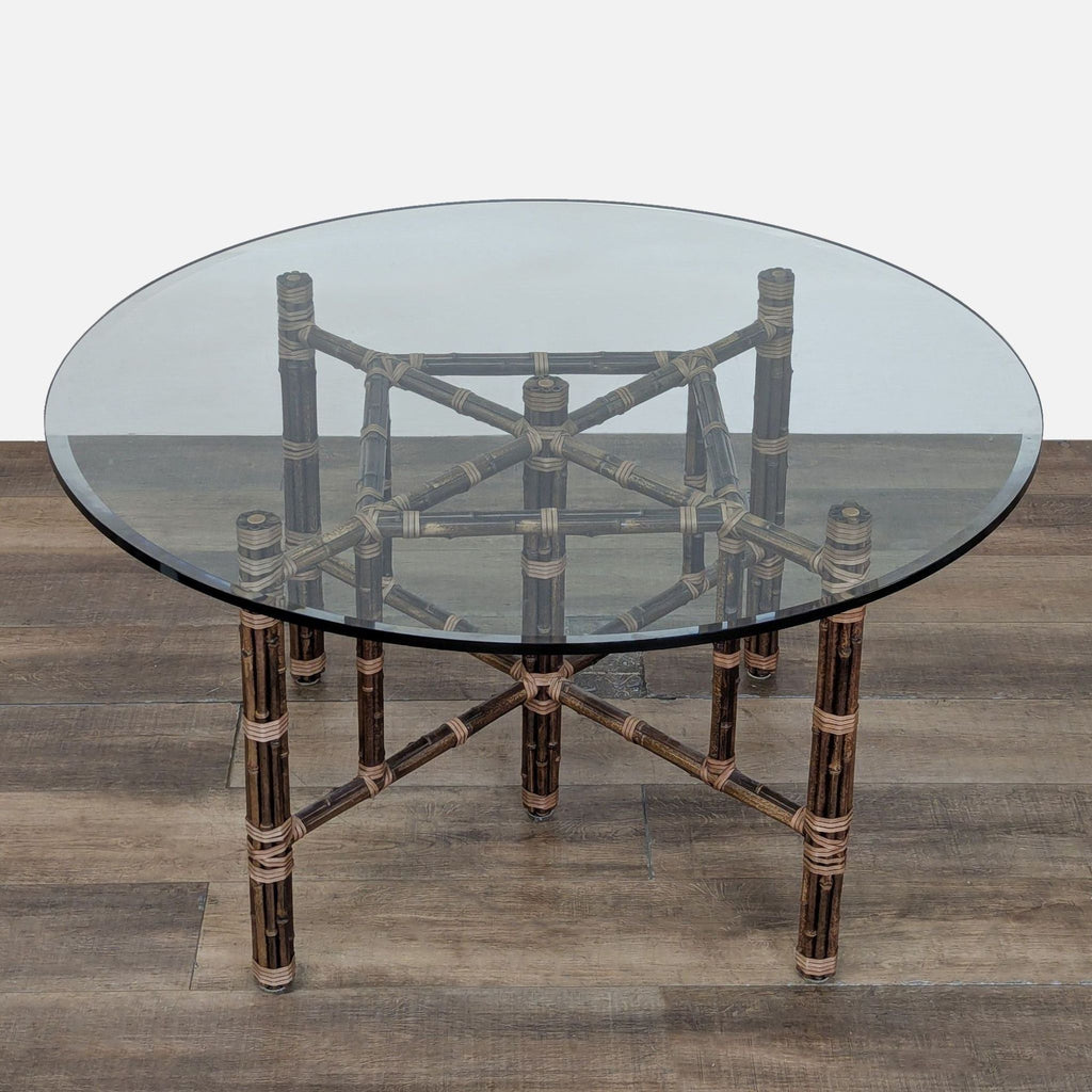 3. Dining table with clear beveled glass top, bamboo legs, and unique leather strap details by McGuire.