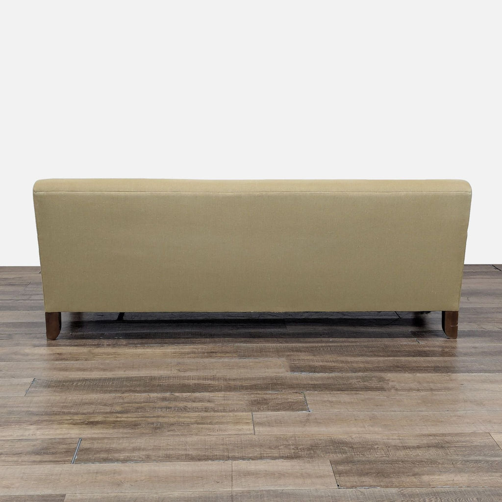 Contemporary Cisco Brothers sofa with sloped arms and tapering wood legs, seats three.