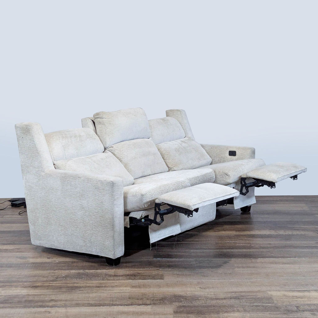 2. Side angle of cream Hancock & Moore 3-seat recliner sofa showing extended footrests and adjustable headrests.