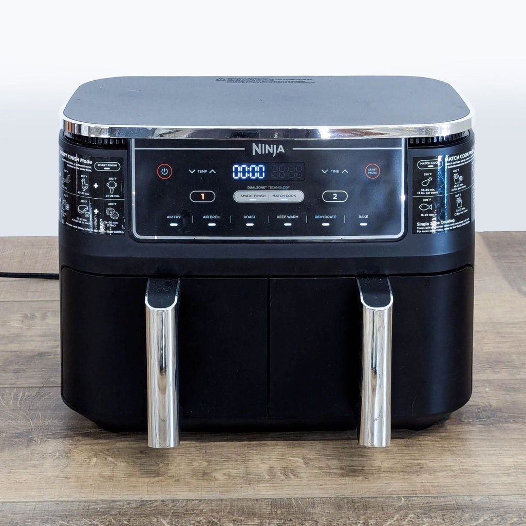 2. Front view of Ninja DualZone Air Fryer showing illuminated digital controls and two chrome handles.  