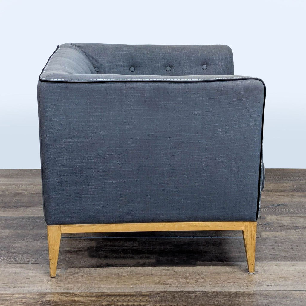 Side view of Moe's lounge chair highlighting its textured fabric and wood legs.  