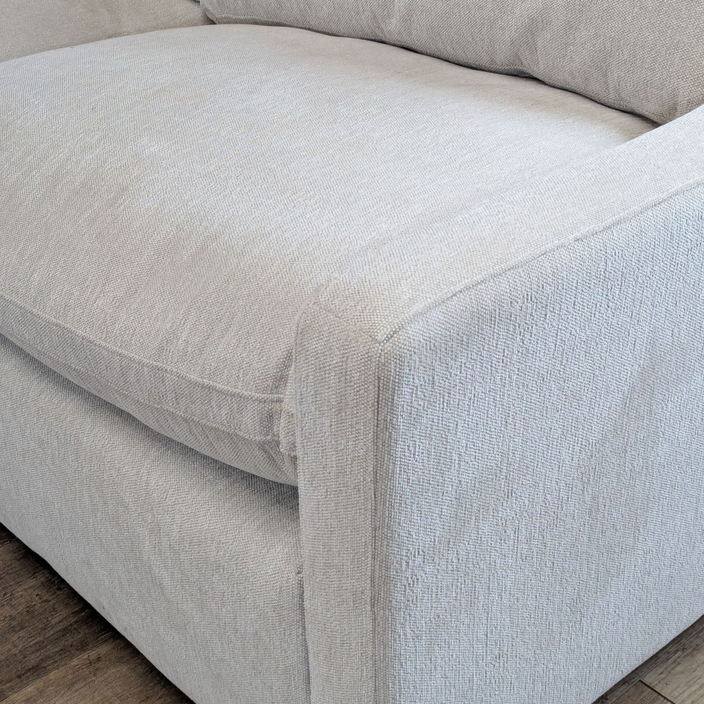 2. Close-up of the Reperch sofa’s cream fabric and slim track arm design for a modern, clean look.