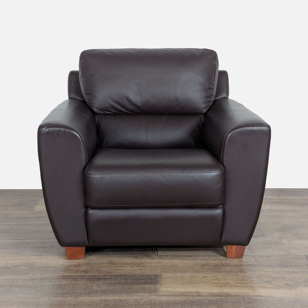 1. Front view of an Ikea lounge chair with brown leather upholstery and tapered wood block feet, placed on wood flooring.