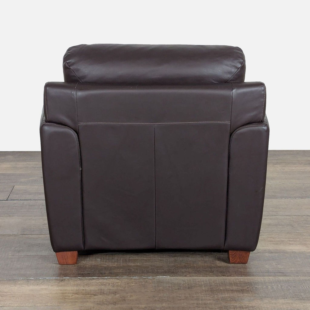 3. Rear view of an Ikea leather-upholstered lounge chair with block wood feet, highlighting its simple modern design.