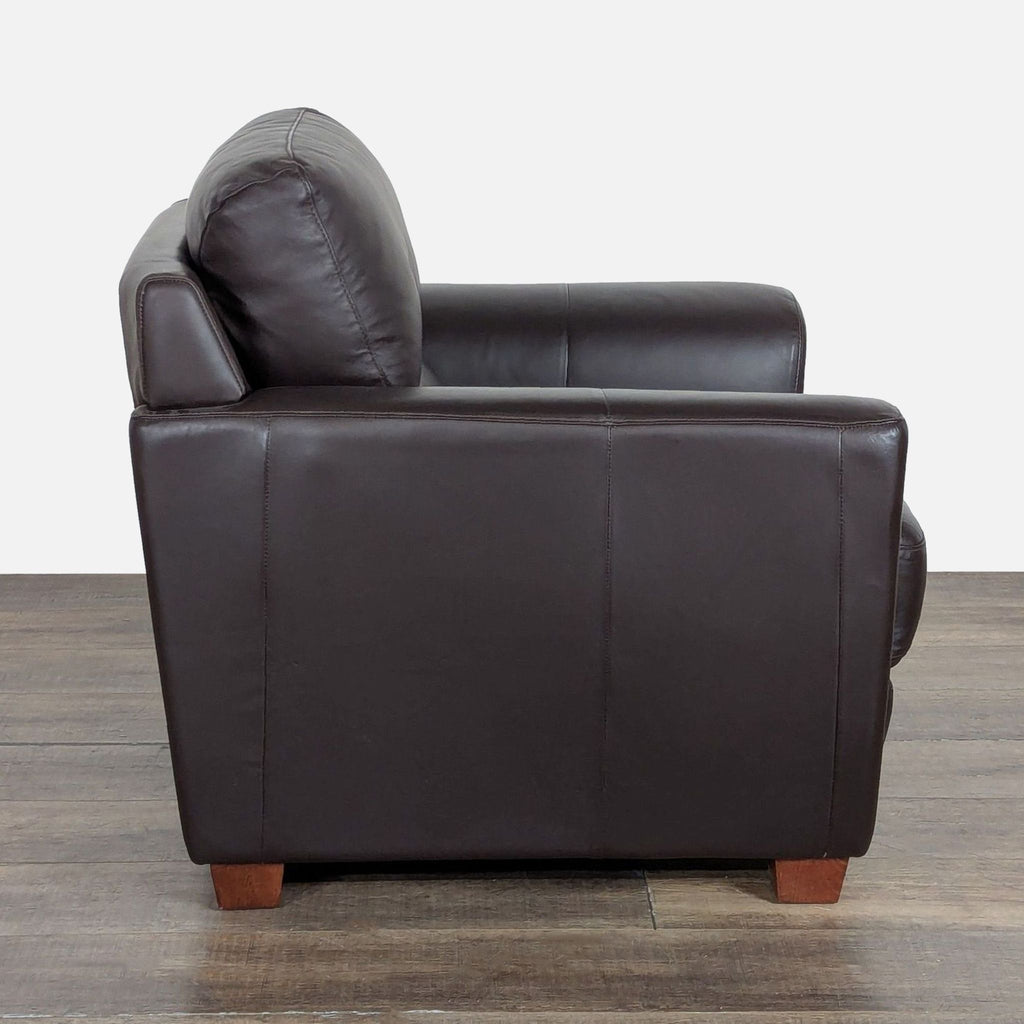 2. Side profile of Ikea lounge chair, showing leather finish and sturdy wooden block feet design.