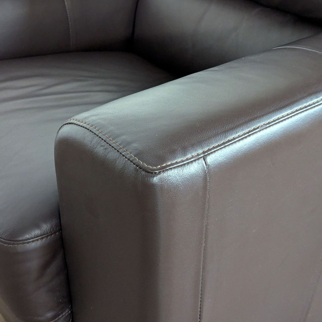 3. Close-up of armrest on Ikea leather lounge chair, highlighting stitching and material texture.