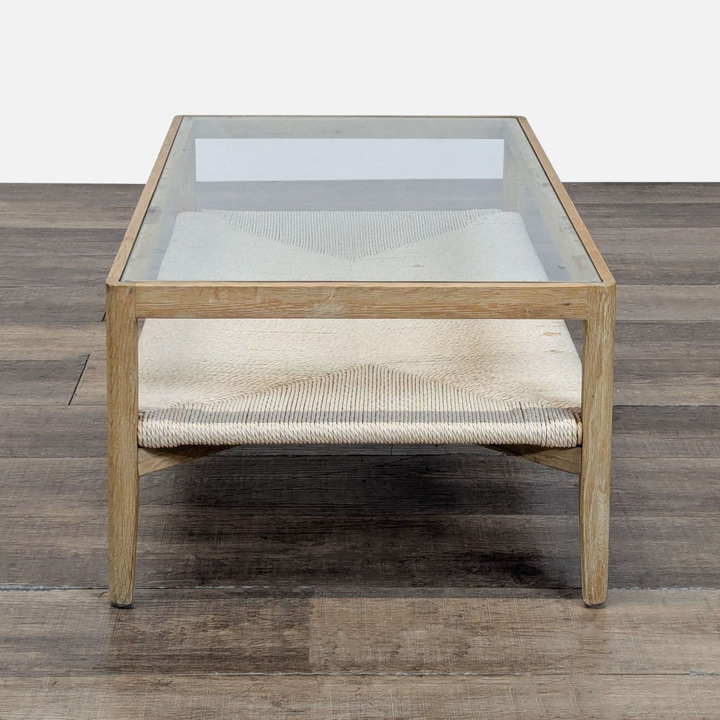 Side view of a Reperch coffee table showing clear glass top and woven shelf in a natural wood frame.