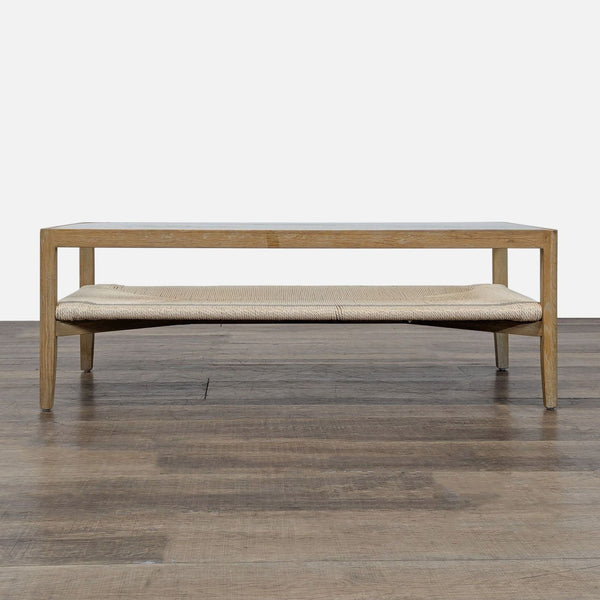 Rectangular Reperch coffee table with light wood frame, glass top, and woven lower shelf. 