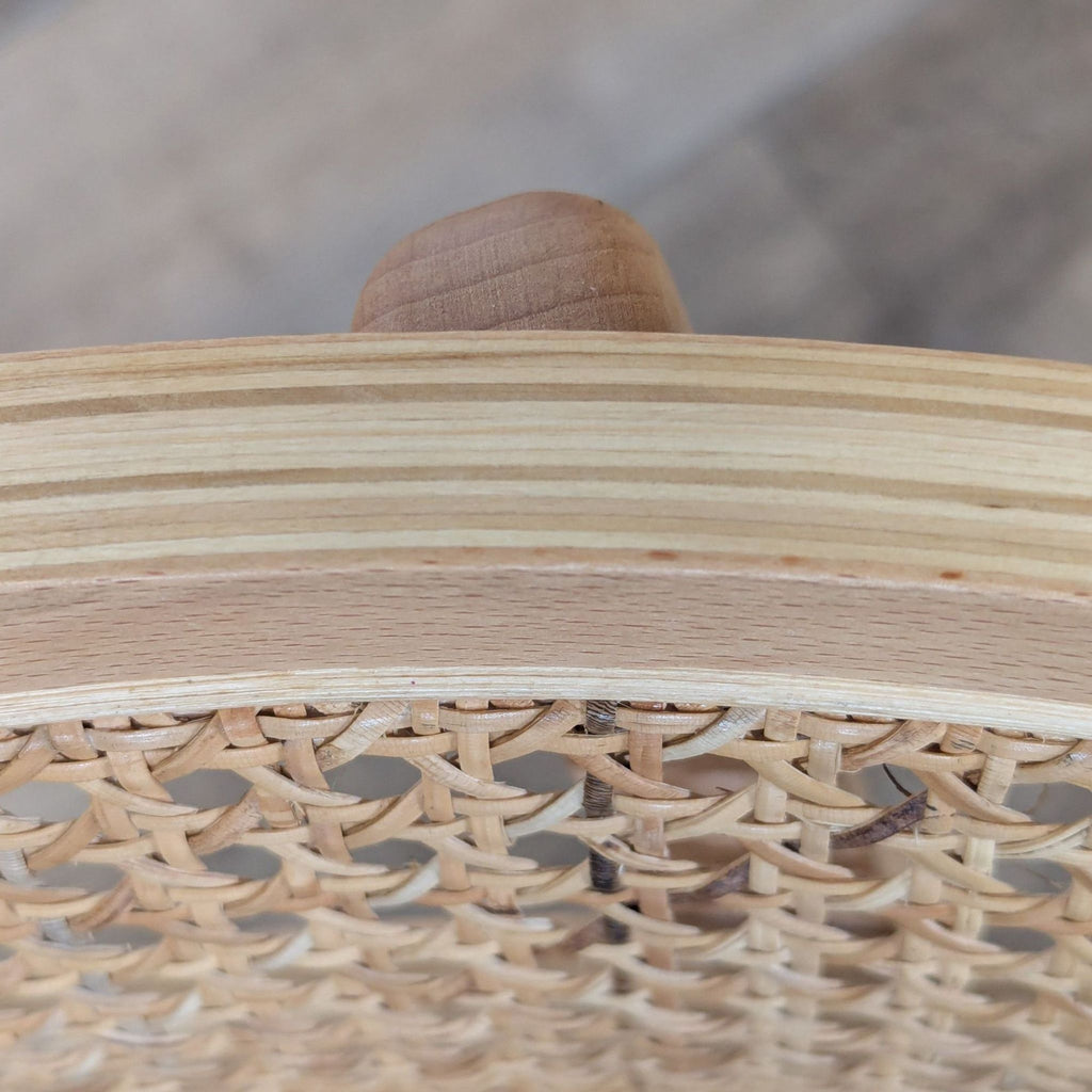 Detailed view of the cane backrest and ash wood frame craftsmanship from a Reperch dining chair.