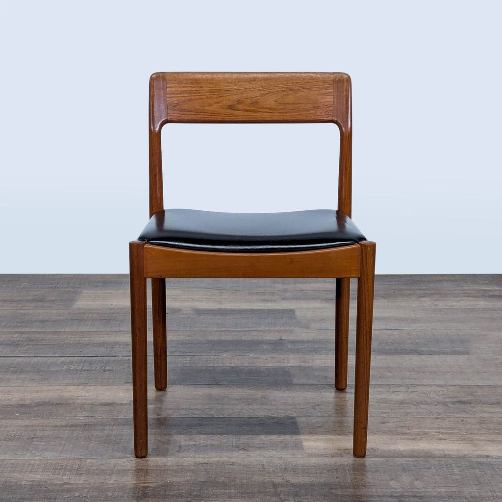 Single vintage Scandinavian teak dining chair with black simili leather seat, front view, Reperch brand.
