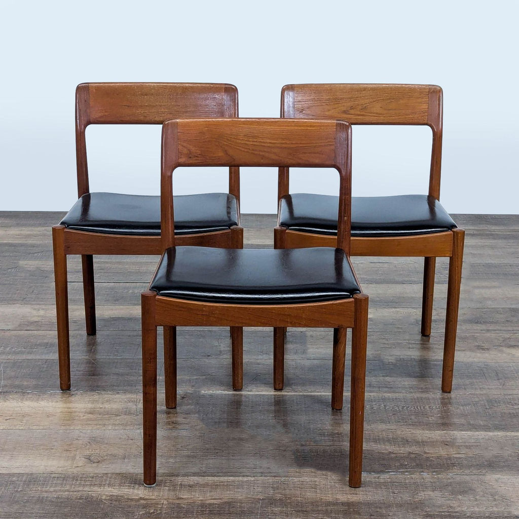 Set of three sculptural teak Scandinavian dining chairs with black simili leather seats, Reperch brand.