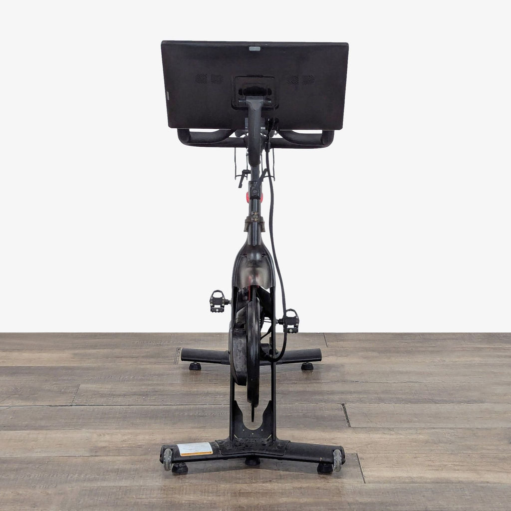 1. Rear view of a Peloton Exercise Bike with touchscreen display, designed for studio-quality home cycling workouts.
