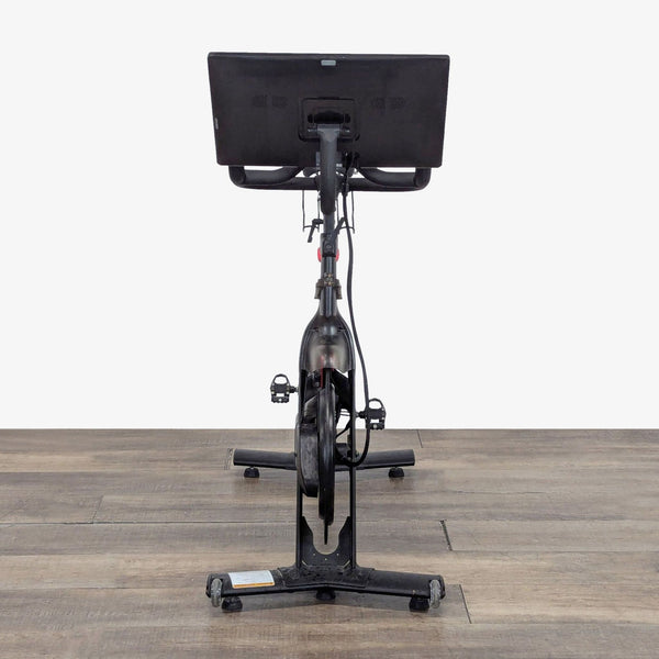 1. Rear view of a Peloton Exercise Bike with touchscreen display, designed for studio-quality home cycling workouts.