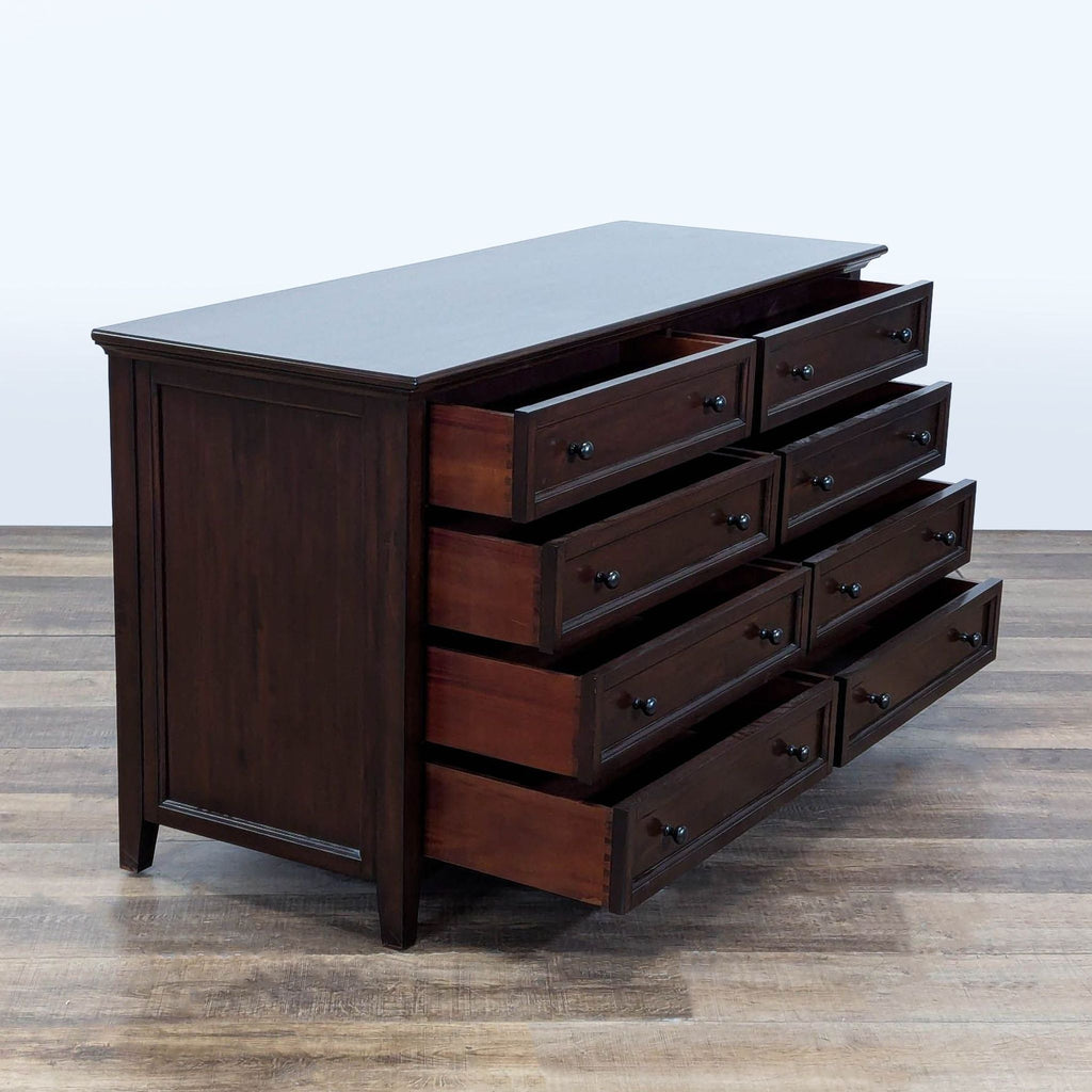 2. Angled view of Pottery Barn dark wood dresser displaying all 8 drawers partially open.