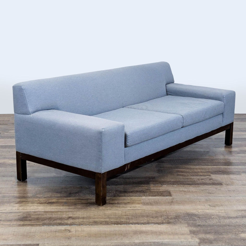 3. Angled view of West Elm 3-seat sofa with light blue fabric, featuring wide track arms and wood legs.