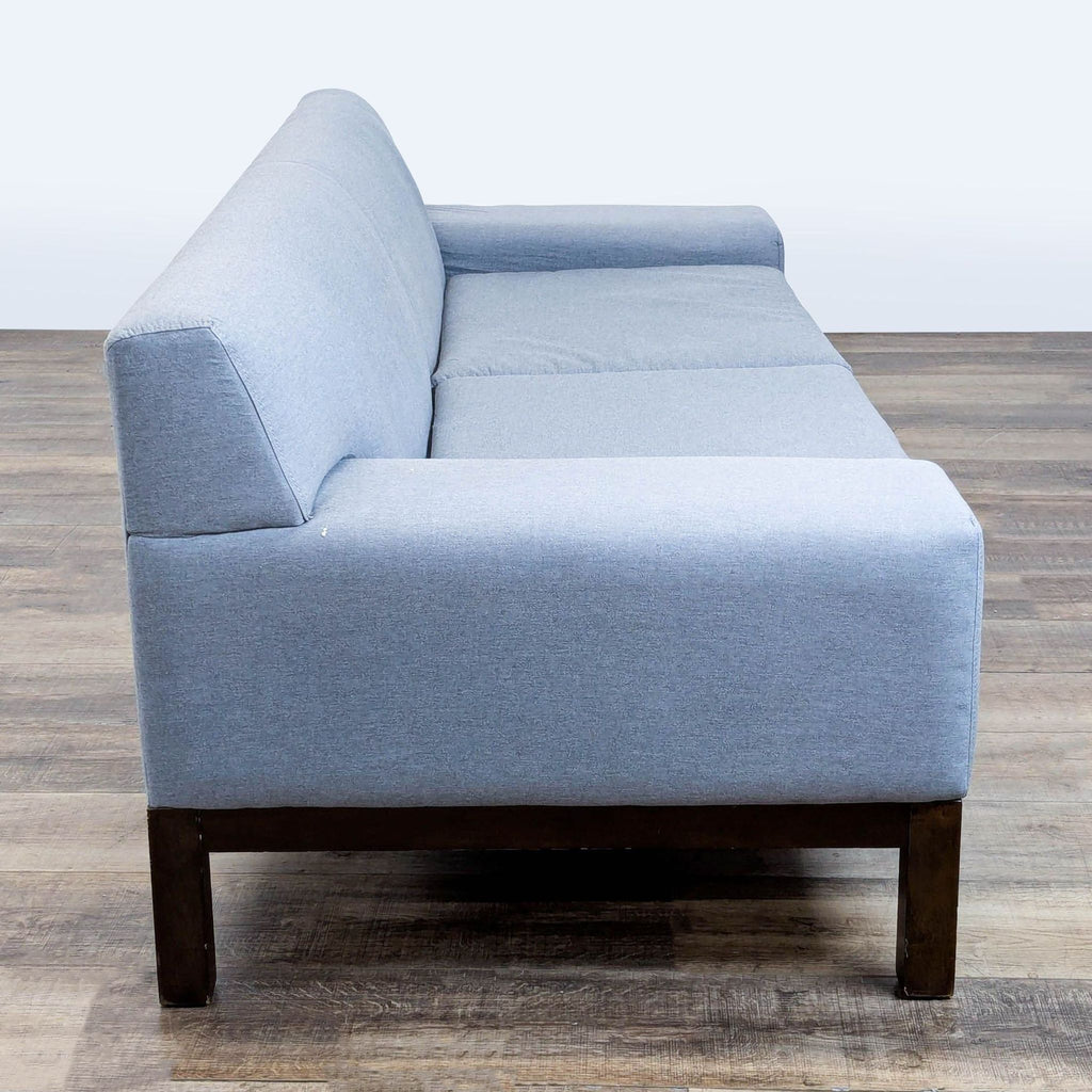 2. Side view of a West Elm 3-seat sofa, showing its wide track arm and sturdy wood legs.