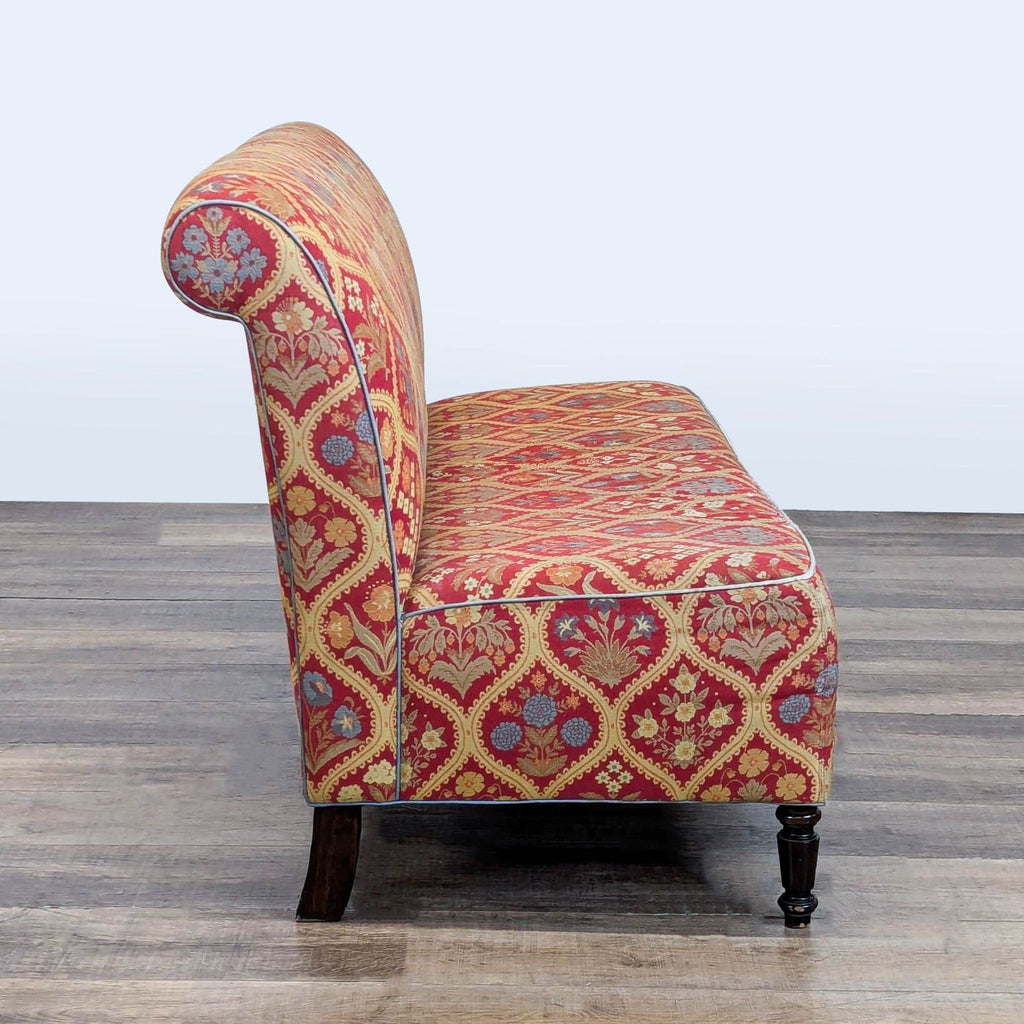 3. Side profile of Reperch upholstered bench featuring scrolled back and decorative red and gold fabric.