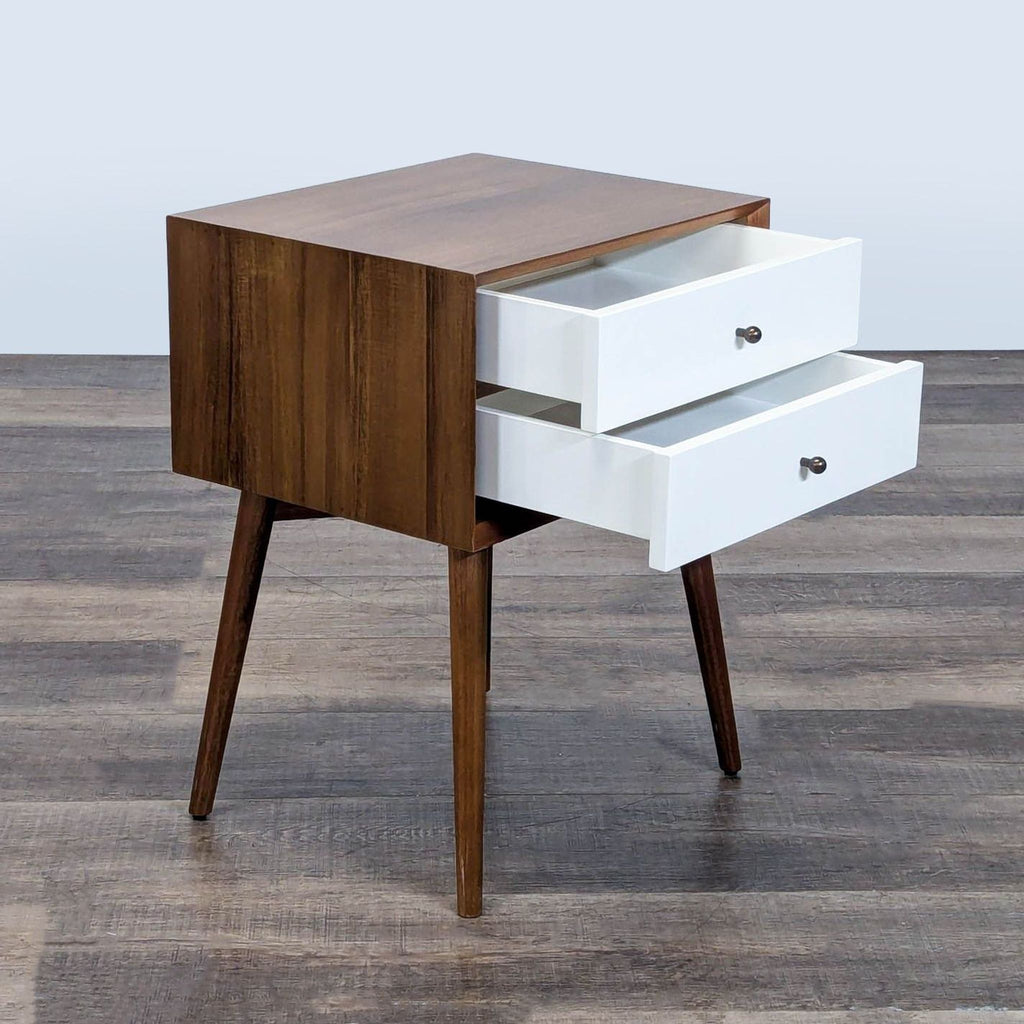 2. Side view of West Elm end table showing two open white drawers and wooden sides on angled legs.