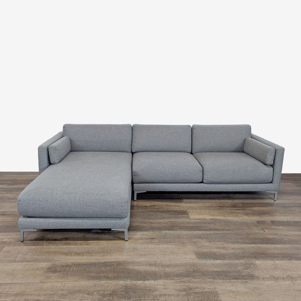 1. CB2 sectional sofa with chaise, track arms, and metal legs, shown in a front view on wood flooring.  