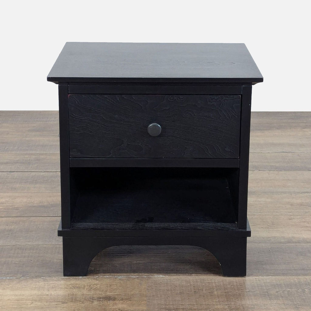 1. Black Pottery Barn side table with one drawer and open shelf, shown against a wood floor background.