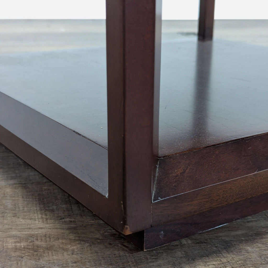 2. Close-up of the Crate & Barrel end table’s lower shelf, showing wood grain and finish details.