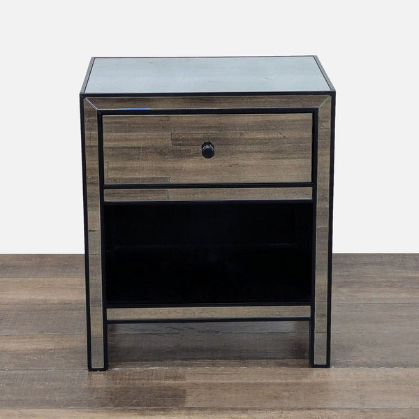 Mirrored Pottery Barn end table with one drawer and open shelf, shown on a wood floor, front view.