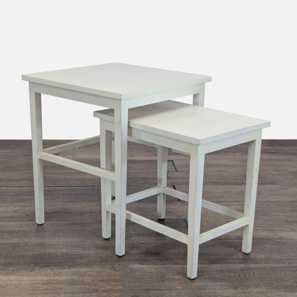 1. Set of two white Reperch end tables, one nested underneath the other, on a wood floor.
