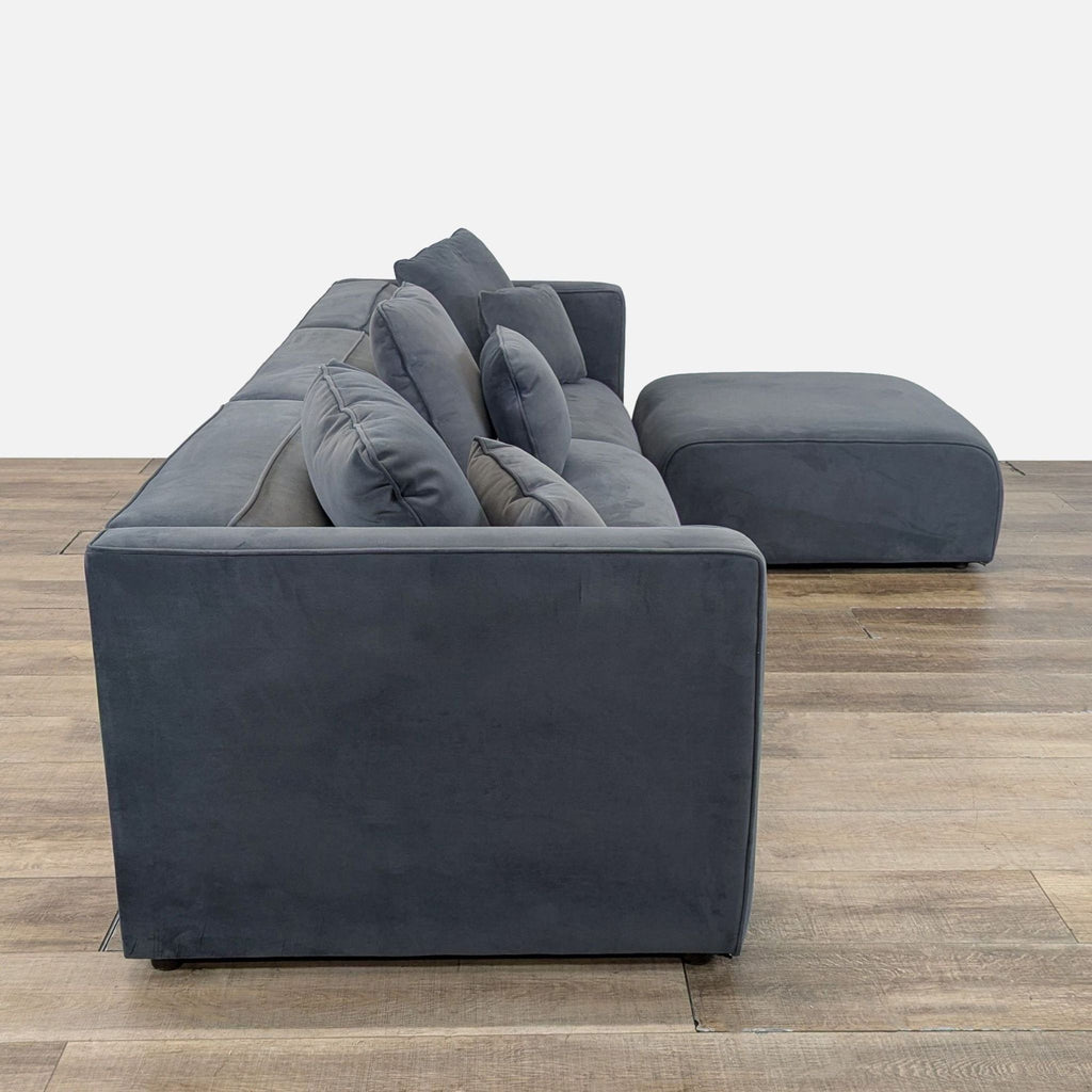 3. Side profile of the Living Spaces sectional sofa in dark gray velvet, highlighting its plush, removable cushions.
