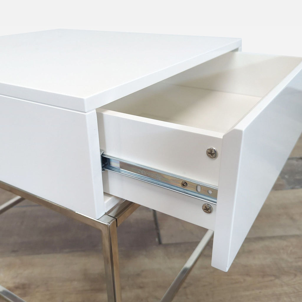 Close-up of the Reperch table's single drawer open, highlighting the metal base and drawer mechanism.