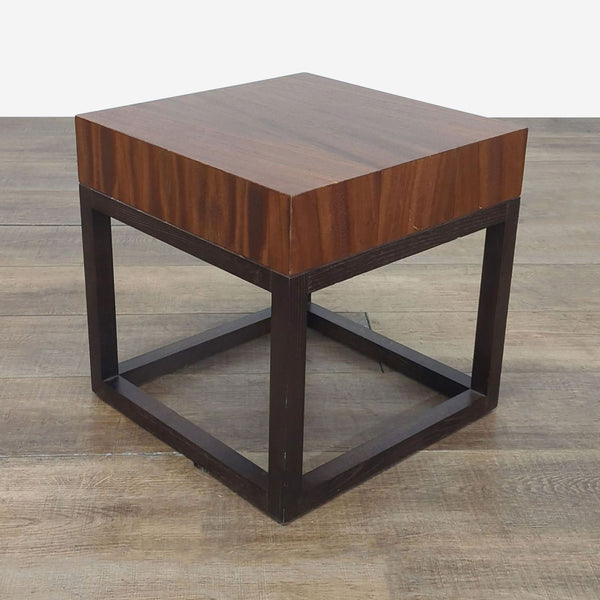 1. Crate & Barrel square side table with wood finish and modern cube-shaped base on a wooden floor.