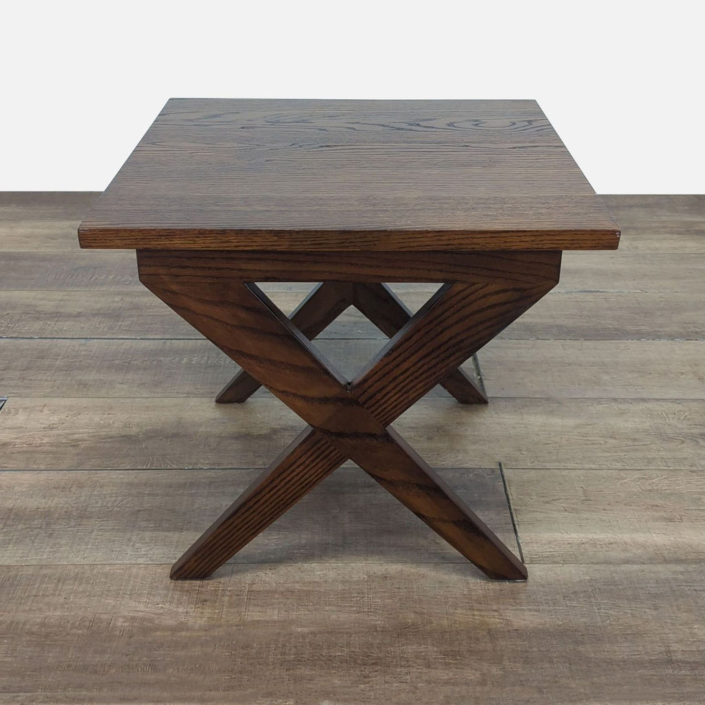 2. Side view of a Reperch dark wood end table, highlighting the geometric X-leg design.
