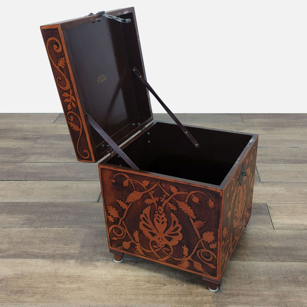 2. South Cone trunk with intricate leaf designs, open lid revealing spacious dark interior, on wooden floor.  