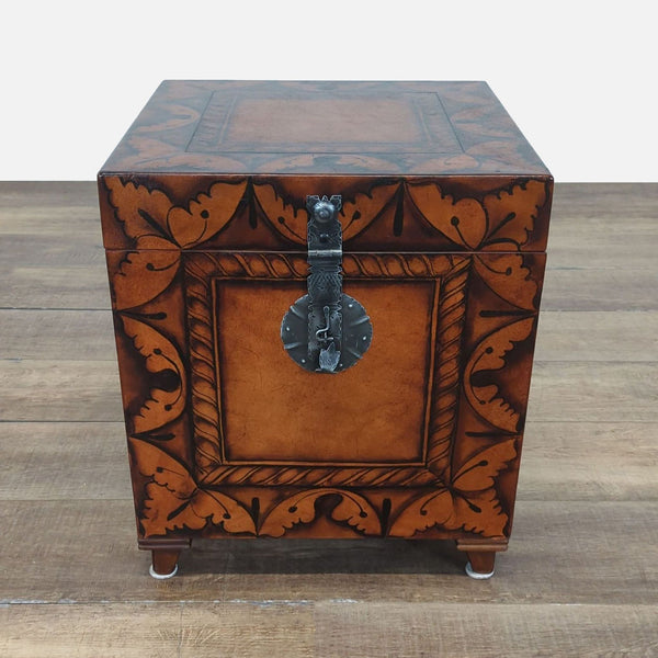 1. Ornate brown wooden trunk by South Cone with decorative leaf patterns and a metal latch on the front.
