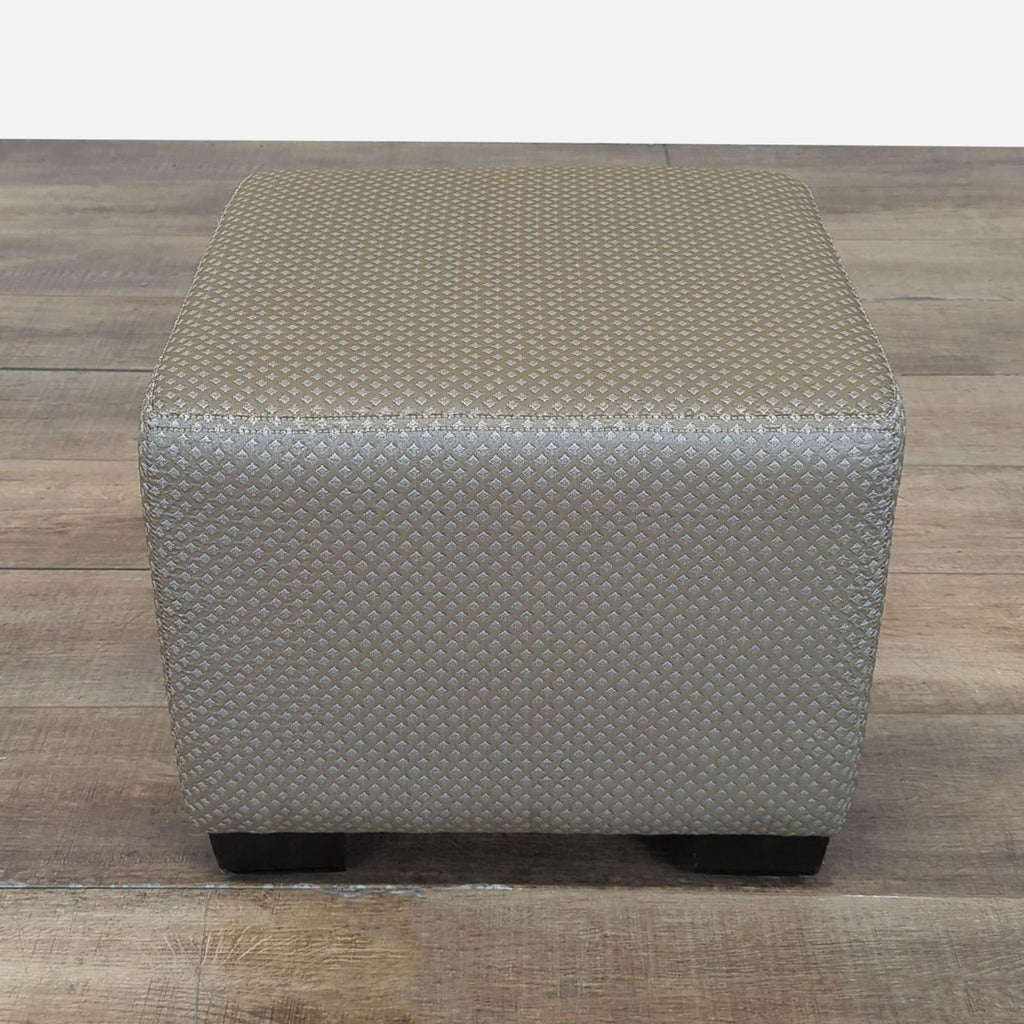 Cisco Bros. ottoman in neutral textured fabric, cube-shaped with short wooden legs, ideal for modern interiors.